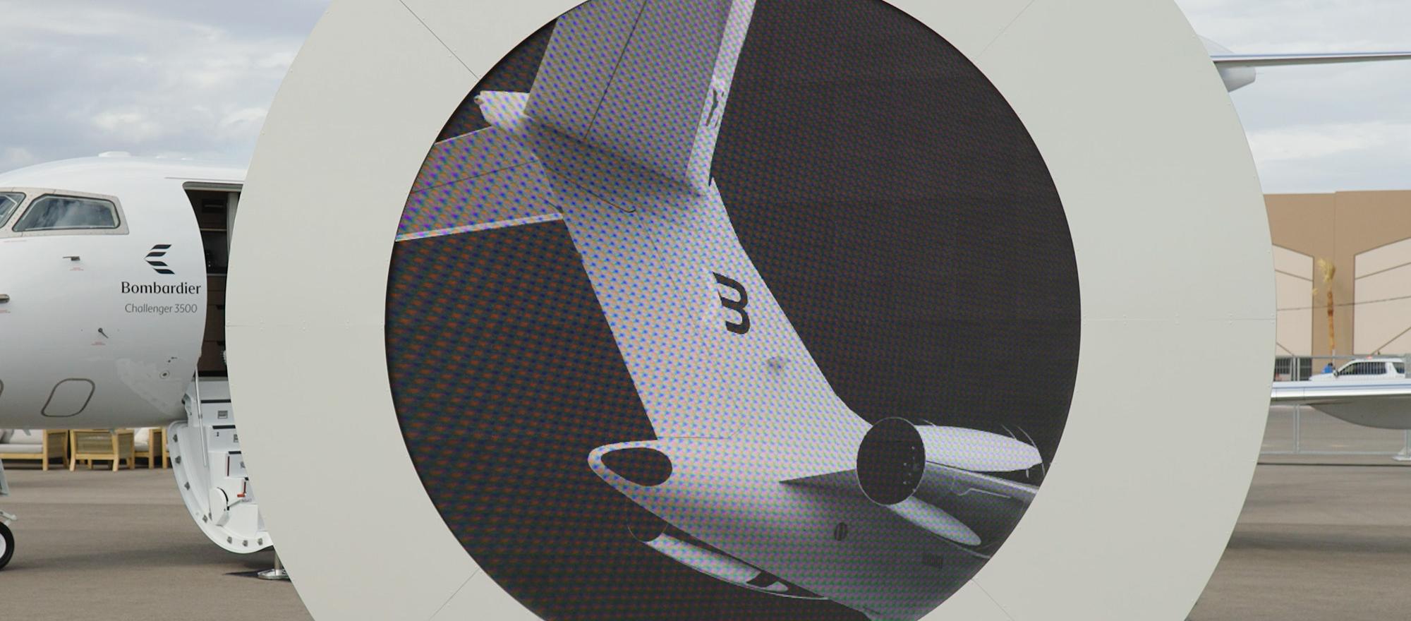 Video screen showing rendering of Bond livery on tail of Bombardier Global aircraft