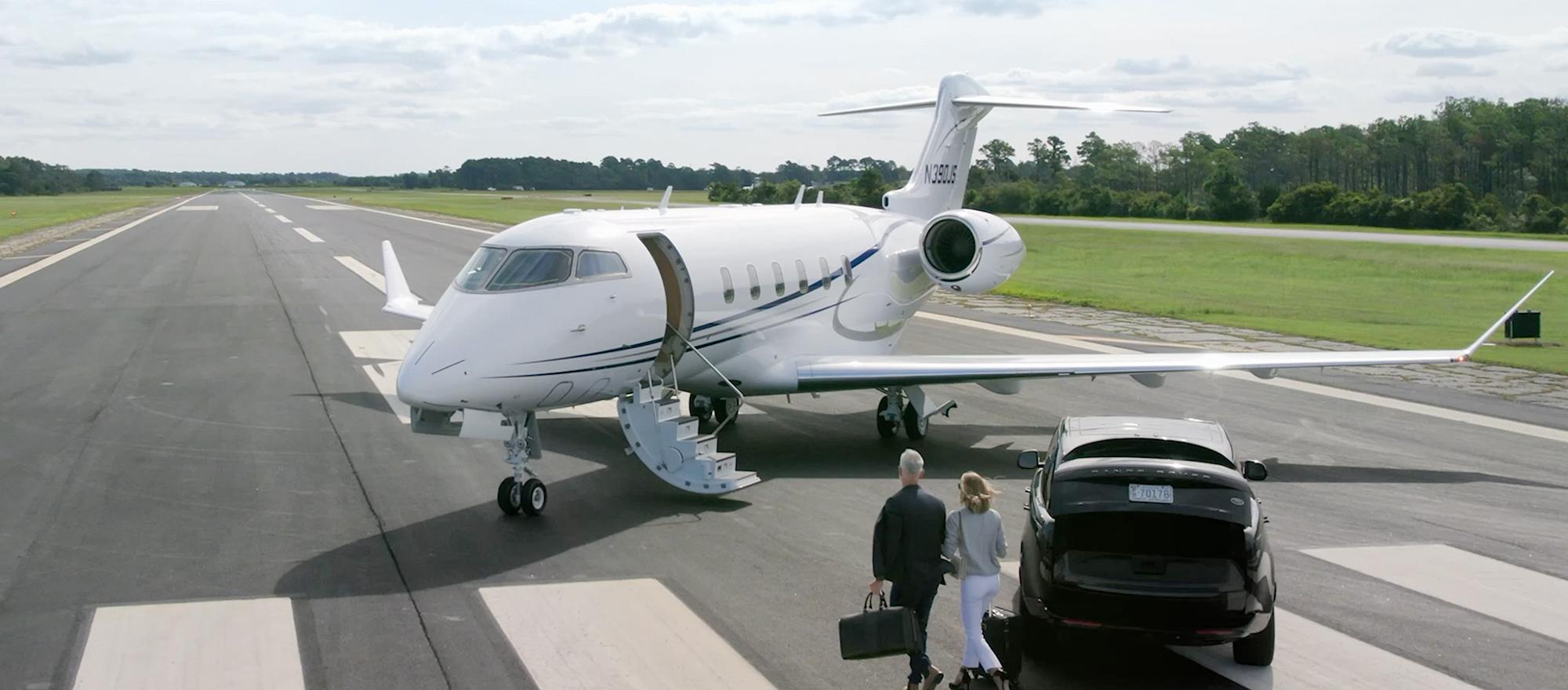 Business jet on runway with people about to board after leaving their car