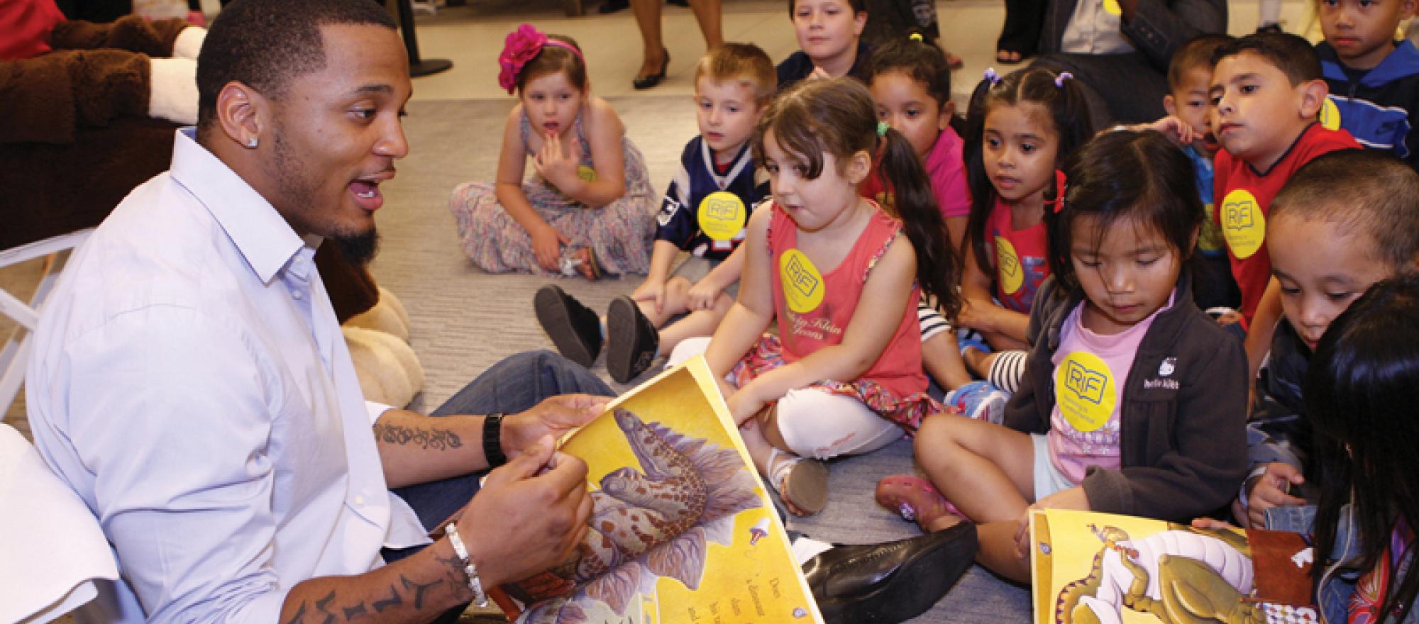 Patrick Chung, player for the New England Patriots, reads to children in Boston at the Macy’s store. Macy’s is a long-time sponsor of RIF.