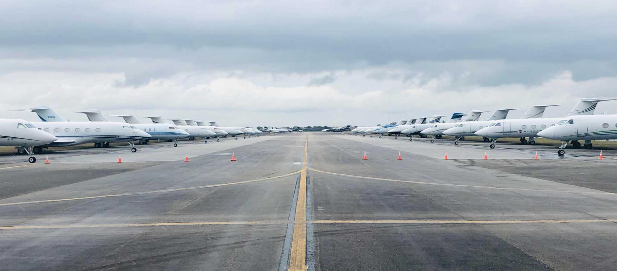 Private jets line a runway used for overflow parking at Miami Opa-locka Executive Airport