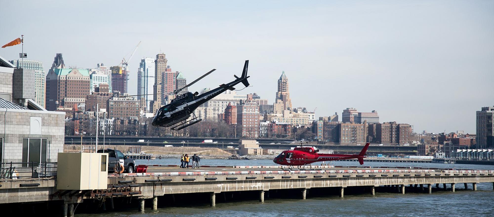 Blade helicopters at heliport in NYC, one coming in for landing