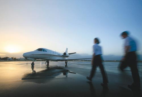 Two NetJets pilots walking out to their airplane.