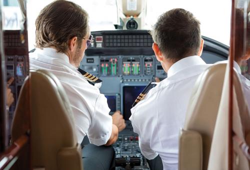 Pilot and copilot in a business jet cabin.