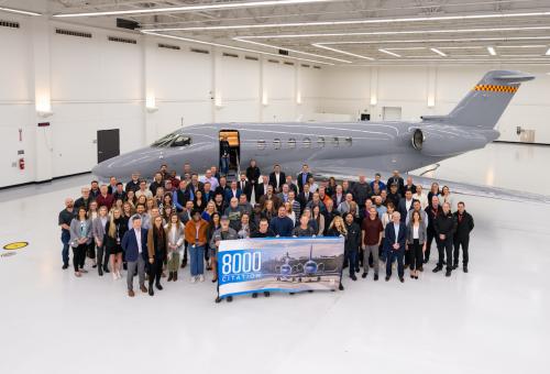 Textron Aviation employees and Scotts Miracle-Gro representatives gather in front of a Cessna Citation Longitude with banner celebrating the 8,000th Citation delivery.