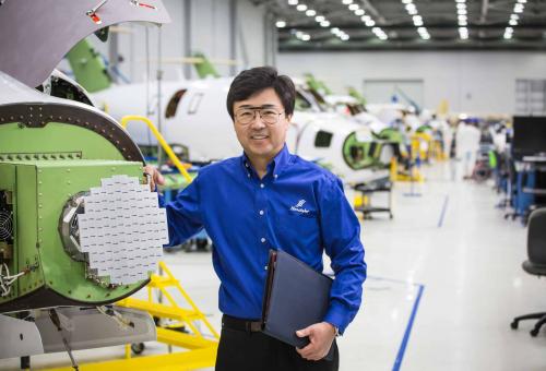 Michimasa Fujino poses with parts of HondaJet fuselage at the company's production facility