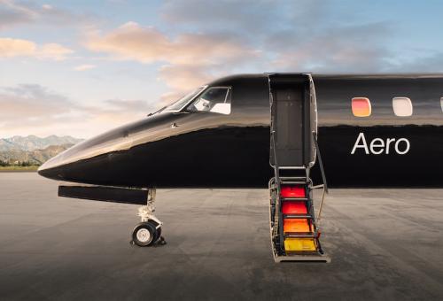 Aero Embraer ERJ-135 parked on airport ramp with door open at sunset