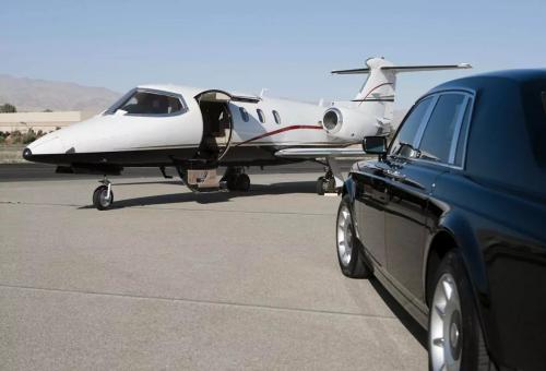 Business jet with door open greeted by courtesy car on airport ramp